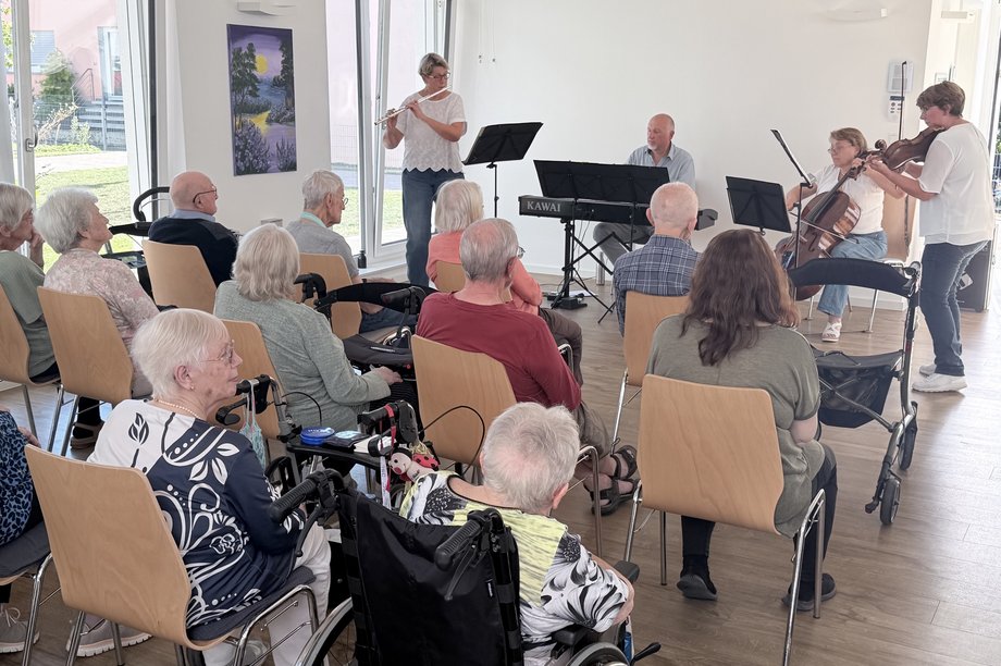 Bewohnerinnen und Bewohner genießen ein Kammermusikkonzert mit Querflöte, Violine, Cello und Klavier im Seniorenzentrum Am Feldrain.