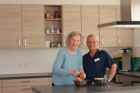 Alltagsbegleiterin kocht mit Seniorin