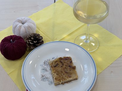 Selbst gebackener Zwiebelkuchen und regionaler Neuer Wein auf herbstlich dekoriertem Tisch im Seniorenzentrum Am Feldrain.