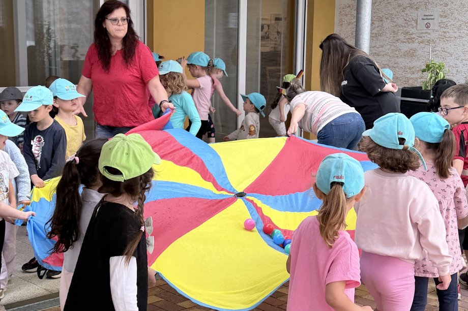 Kinder drehen sich im Kreis mit einem Schwungtuch