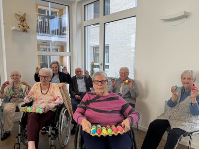 Bewohner/-innen zeigen ihre bunt gefärbten Eier
